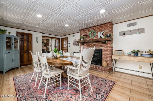937 E 10th St, Berwick, PA 18603 - dining room featuring an ornate ceiling, baseboard heating, recessed lighting, a brick fireplace, and light tile patterned flooring