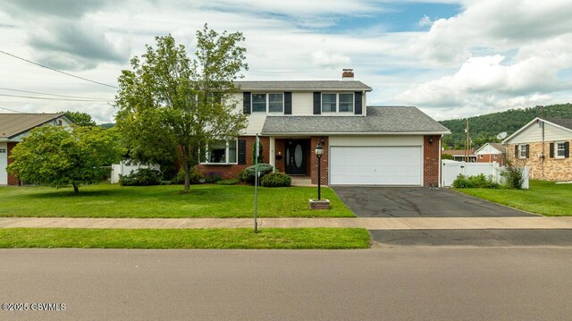 937 E 10th St, Berwick, PA 18603 - traditional-style house featuring a chimney, asphalt driveway, brick siding, and an attached garage