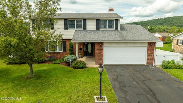 937 E 10th St, Berwick, PA 18603 - view of front of property featuring a chimney, asphalt driveway, brick siding, and a garage