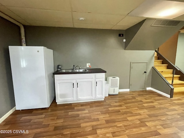 3014 Smoketown Rd, Lewisburg, PA 17837 - kitchen with freestanding refrigerator, a sink, dark countertops, white cabinets, and light wood finished floors