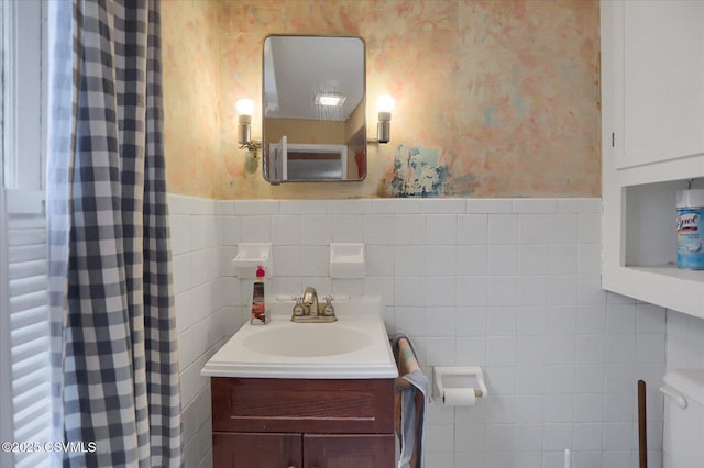 205 N Water St, Selinsgrove, PA 17870 - bathroom with toilet, wainscoting, vanity, tile walls, and wallpapered walls