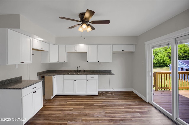 2196 Continental Blvd, Danville, PA 17821 - kitchen featuring a sink, ceiling fan, dark wood-style flooring, dark countertops, and white cabinetry