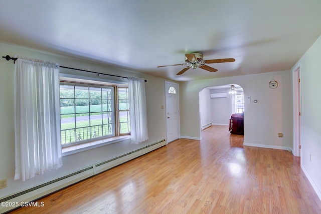 4123 Troxelville Rd, Middleburg, PA 17842 - unfurnished room featuring a baseboard heating unit, arched walkways, ceiling fan, and plenty of natural light