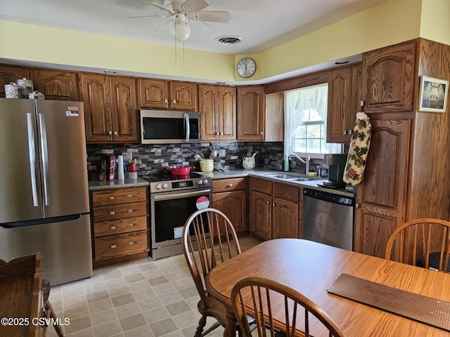 1605 W Montgomery St, Coal Township, PA 17866 - kitchen featuring appliances with stainless steel finishes, a sink, ceiling fan, and tasteful backsplash