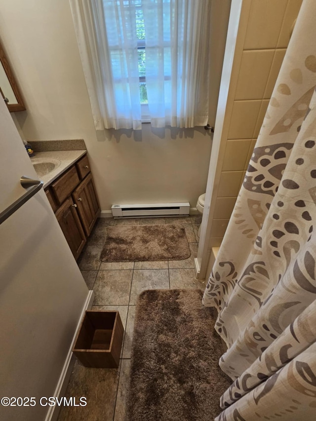 1605 W Montgomery St, Coal Township, PA 17866 - bathroom featuring a baseboard heating unit, vanity, toilet, baseboards, and tile patterned flooring