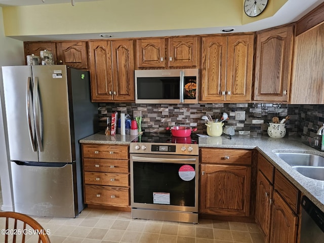 1605 W Montgomery St, Coal Township, PA 17866 - kitchen with stainless steel appliances, a sink, brown cabinetry, and decorative backsplash