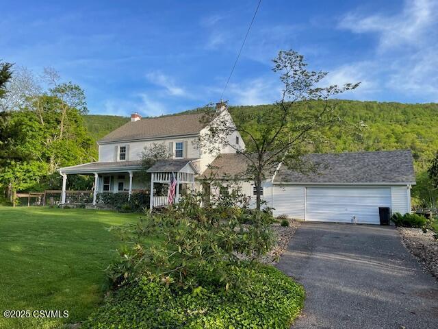 2852 State Route 487, Orangeville, PA 17859 - view of front of house with driveway, a front lawn, a garage, a porch, and a chimney