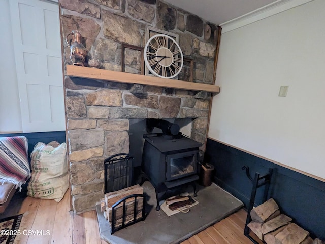 2852 State Route 487, Orangeville, PA 17859 - detailed view of a wood stove, crown molding, wood finished floors, and a wainscoted wall