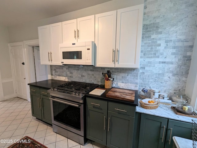2852 State Route 487, Orangeville, PA 17859 - kitchen with white microwave, stainless steel gas range, white cabinetry, light tile patterned floors, and backsplash