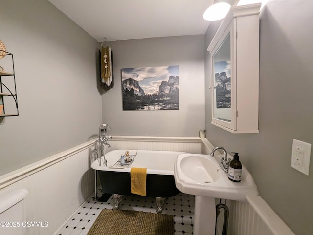 2852 State Route 487, Orangeville, PA 17859 - full bathroom with a freestanding bath, toilet, tile patterned floors, a wainscoted wall, and a sink