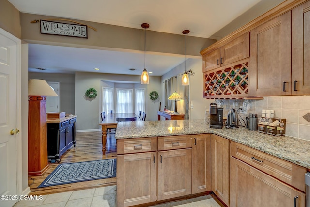 475 W 1st St, Bloomsburg, PA 17815 - kitchen with a peninsula, light stone counters, backsplash, pendant lighting, and baseboards