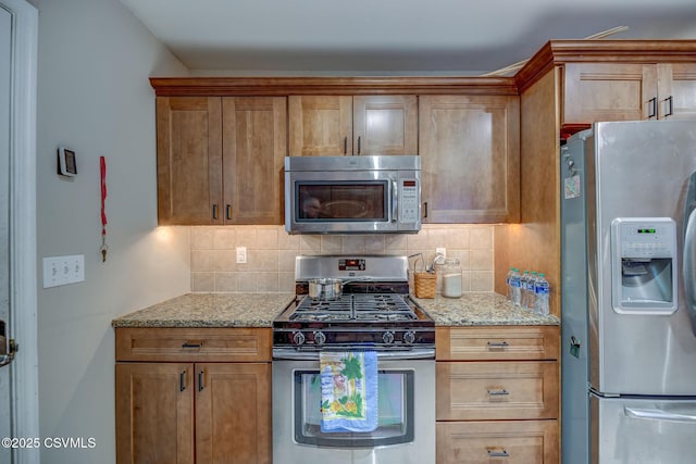 475 W 1st St, Bloomsburg, PA 17815 - kitchen featuring appliances with stainless steel finishes, decorative backsplash, light stone countertops, and brown cabinets