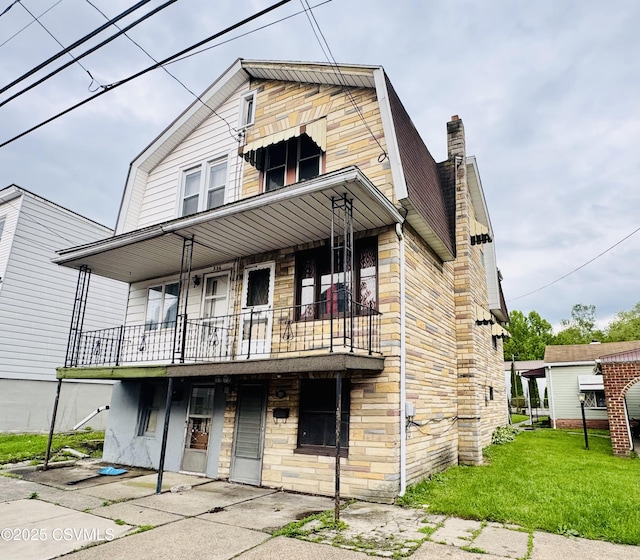 338 W Saylor St, Atlas, PA 17851 - view of front of house featuring a gambrel roof, a balcony, stone siding, and a front yard