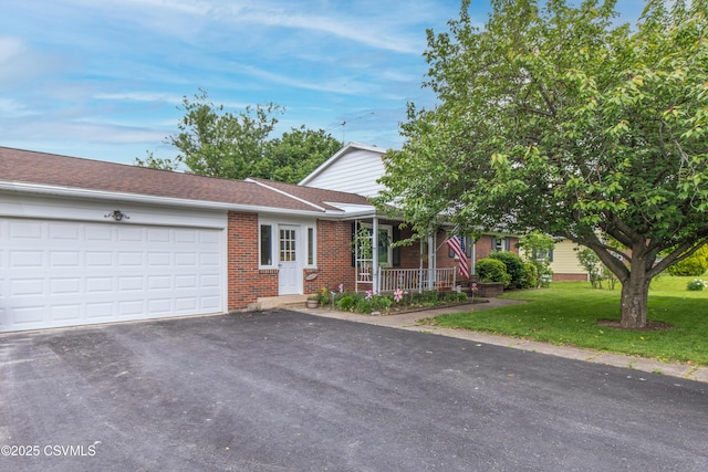 2256 Crossroads Dr, Lewisburg, PA 17837 - view of front of property with brick siding, asphalt driveway, an attached garage, a porch, and a front lawn