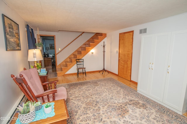 2256 Crossroads Dr, Lewisburg, PA 17837 - sitting room with stairway, wood finished floors, and a baseboard heating unit