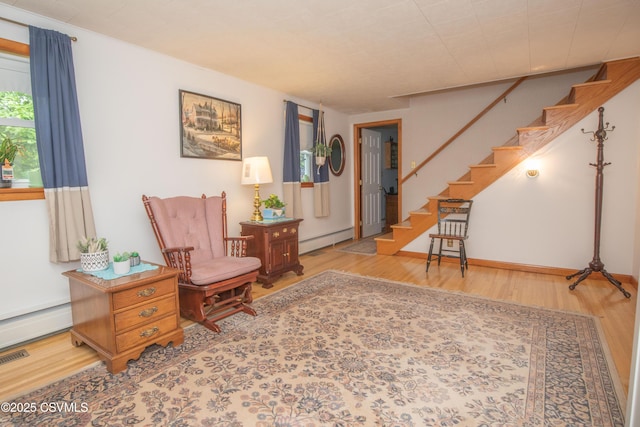 2256 Crossroads Dr, Lewisburg, PA 17837 - living area with wood finished floors, a baseboard radiator, stairs, and a baseboard heating unit