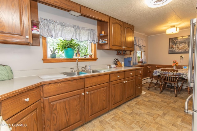 2256 Crossroads Dr, Lewisburg, PA 17837 - kitchen featuring brown cabinetry, a sink, light countertops, stone finish floors, and baseboard heating