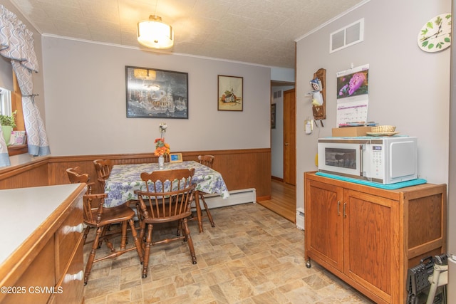 2256 Crossroads Dr, Lewisburg, PA 17837 - dining area featuring ornamental molding, stone finish flooring, wood walls, wainscoting, and a baseboard heating unit