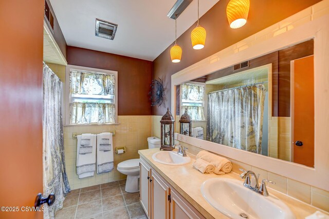 1207 E 5th St, Berwick, PA 18603 - full bathroom featuring tile patterned floors, toilet, healthy amount of natural light, tile walls, and double vanity