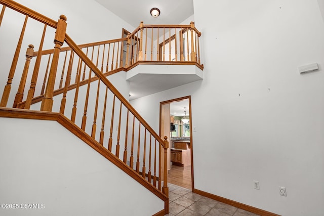 620 Sunset Dr, Bloomsburg, PA 17815 - staircase featuring baseboards, tile patterned floors, and a high ceiling