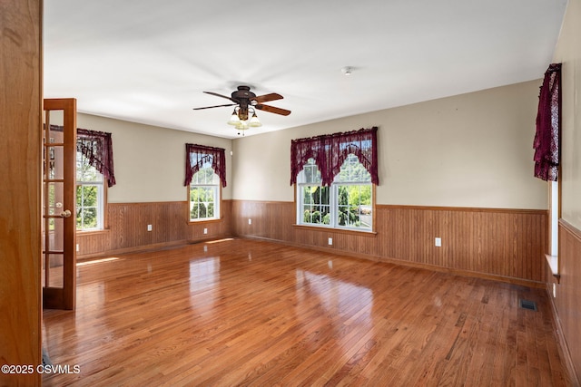 620 Sunset Dr, Bloomsburg, PA 17815 - unfurnished room featuring a wainscoted wall, wood finished floors, a ceiling fan, and wooden walls