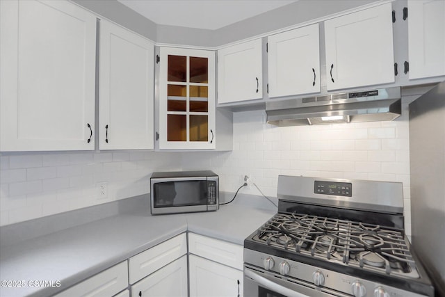 521 Church St, Danville, PA 17821 - kitchen featuring appliances with stainless steel finishes, extractor fan, white cabinets, and decorative backsplash
