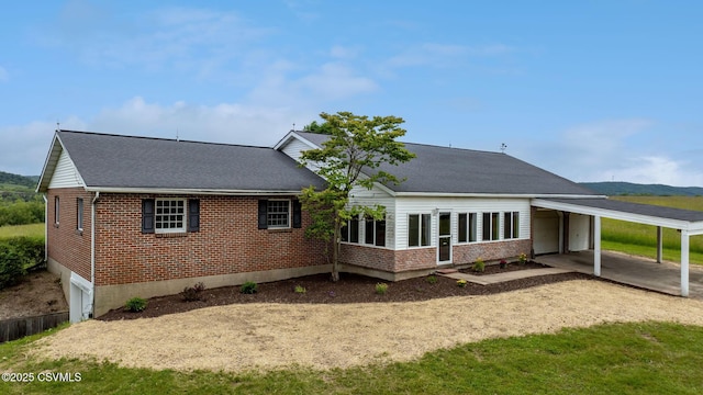 162 Liberty Valley Rd, Danville, PA 17821 - back of house with brick siding, dirt driveway, a carport, and roof with shingles