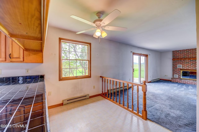 162 Liberty Valley Rd, Danville, PA 17821 - kitchen featuring a baseboard heating unit, baseboards, a ceiling fan, and a fireplace