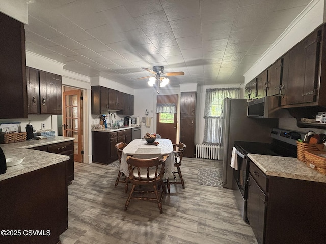 321 E Shamokin St, Trevorton, PA 17881 - kitchen featuring appliances with stainless steel finishes, radiator heating unit, dark brown cabinets, and ceiling fan