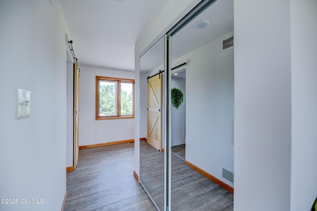 67 Center School Rd, Elysburg, PA 17824 - hall featuring a barn door, wood finished floors, and baseboards