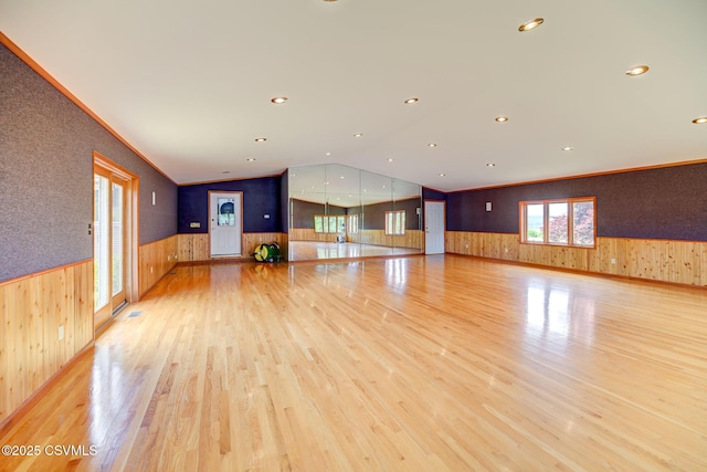 67 Center School Rd, Elysburg, PA 17824 - unfurnished living room with a wainscoted wall, wood walls, light wood-style floors, lofted ceiling, and recessed lighting