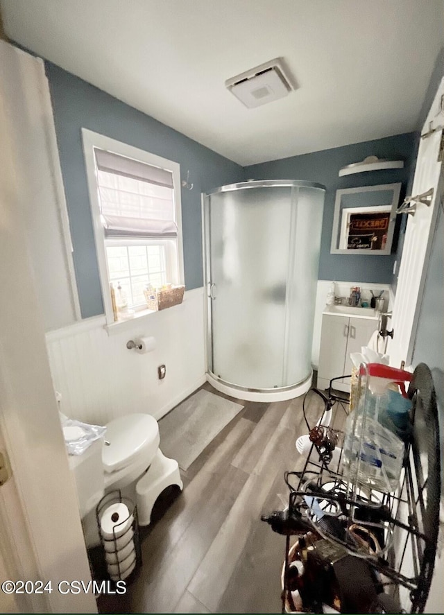 406 W Spruce St, Shamokin, PA 17872 - bathroom with wood finished floors, a shower stall, toilet, wainscoting, and a sink