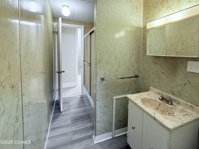 423 E Dewart St, Shamokin, PA 17872 - bathroom featuring wood finished floors, vanity, a shower with shower door, and baseboards