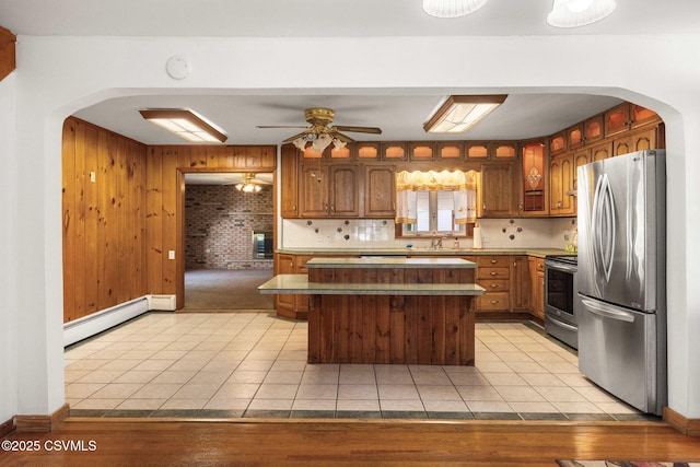 776 Continental Blvd, Danville, PA 17821 - kitchen with appliances with stainless steel finishes, arched walkways, baseboard heating, light tile patterned flooring, and wooden walls