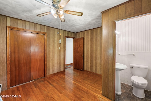 776 Continental Blvd, Danville, PA 17821 - unfurnished bedroom with a closet, connected bathroom, wood finished floors, ceiling fan, and wooden walls