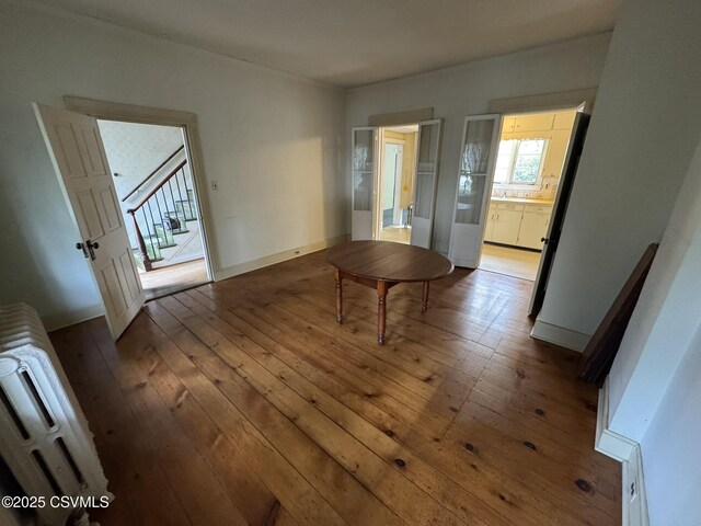 127 N 3rd St, Lewisburg, PA 17837 - unfurnished dining area featuring hardwood / wood-style flooring, stairs, and radiator heating unit
