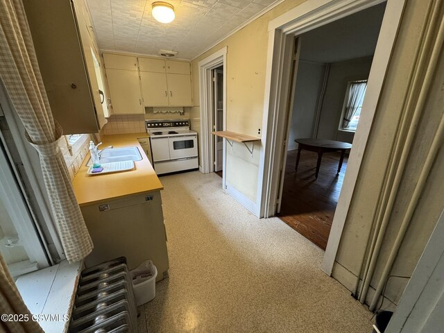 127 N 3rd St, Lewisburg, PA 17837 - kitchen with electric range, light countertops, a sink, white cabinets, and decorative backsplash