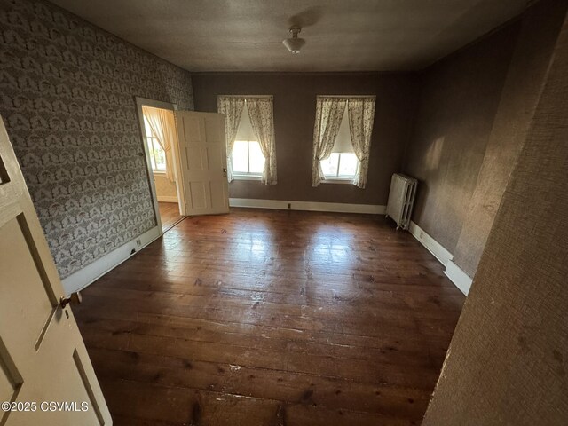 127 N 3rd St, Lewisburg, PA 17837 - empty room with radiator heating unit, wallpapered walls, hardwood / wood-style flooring, and baseboards