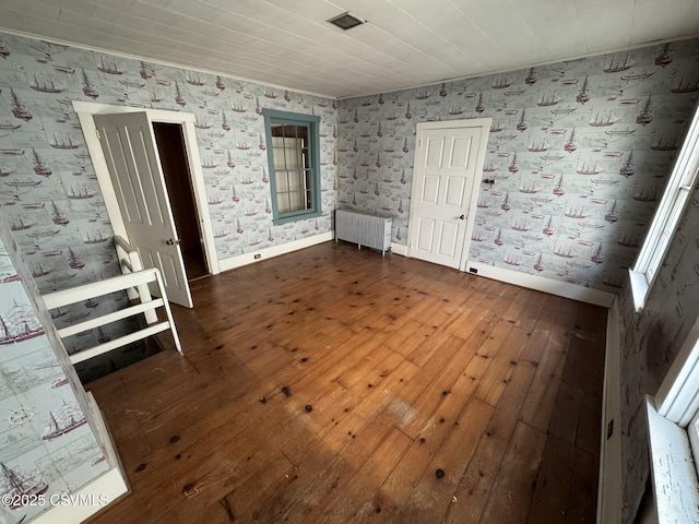 127 N 3rd St, Lewisburg, PA 17837 - empty room featuring radiator, dark wood-style flooring, baseboards, wallpapered walls, and crown molding