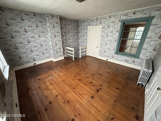 127 N 3rd St, Lewisburg, PA 17837 - unfurnished room featuring hardwood / wood-style floors, baseboards, wallpapered walls, and heating unit