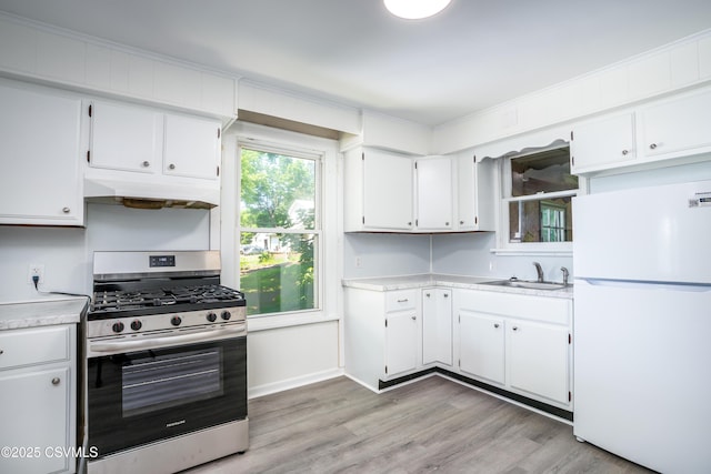 1355 Salem Blvd, Berwick, PA 18603 - kitchen with freestanding refrigerator, stainless steel gas range oven, under cabinet range hood, light countertops, and light wood-style flooring