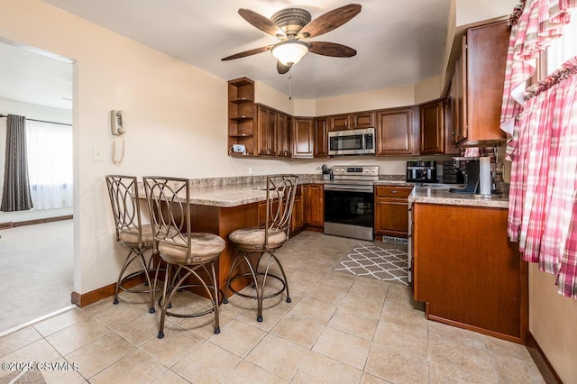 306 Clybourne Ave, Berwick, PA 18603 - kitchen with stainless steel appliances, ceiling fan, open shelves, baseboards, and light countertops