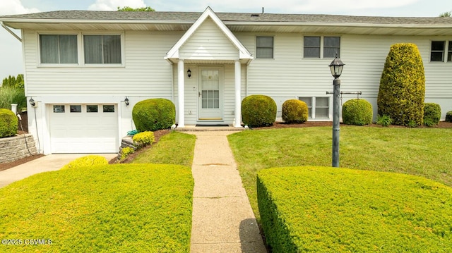 306 Clybourne Ave, Berwick, PA 18603 - bi-level home featuring a garage, concrete driveway, and a front lawn