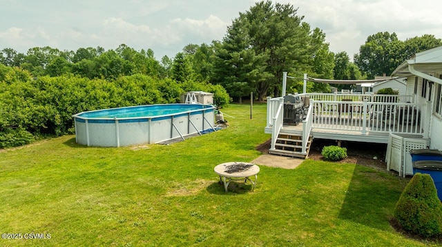 306 Clybourne Ave, Berwick, PA 18603 - view of green lawn featuring an outdoor fire pit, a wooden deck, an outdoor pool, and view of wooded area