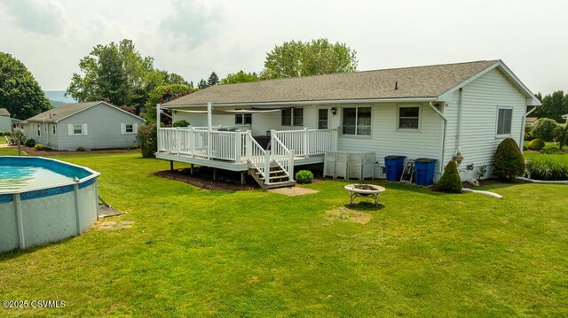 306 Clybourne Ave, Berwick, PA 18603 - rear view of property with an outdoor fire pit, a wooden deck, an outdoor pool, and a lawn