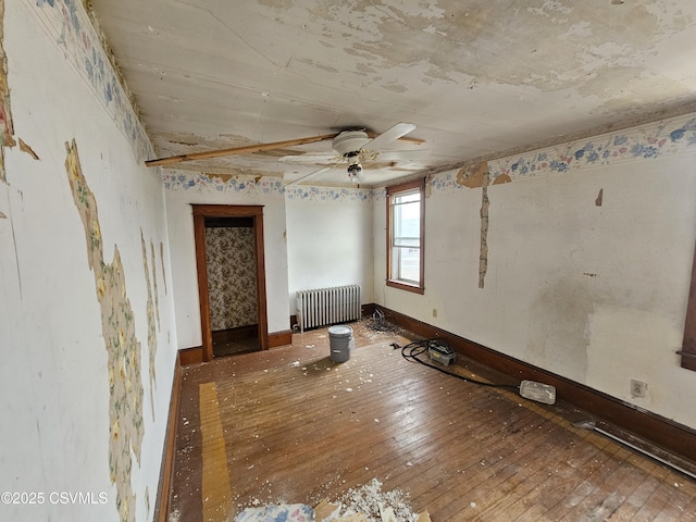 334 W Butternut St, Mount Carmel, PA 17851 - empty room with radiator, a ceiling fan, and hardwood / wood-style floors