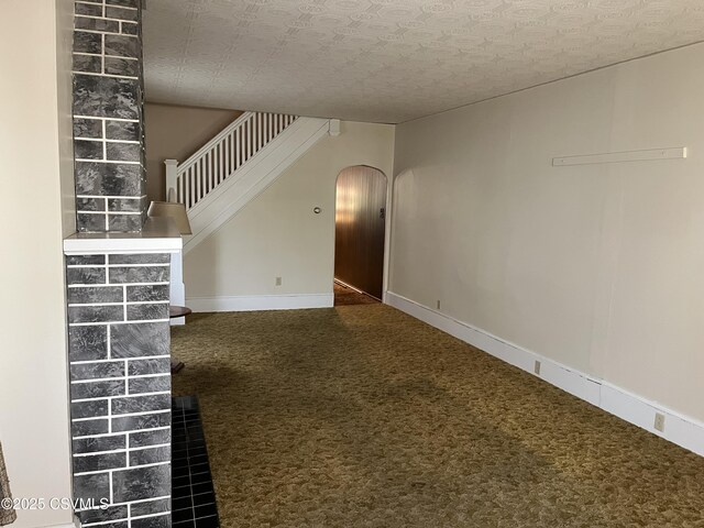 1409 Scott St, Kulpmont, PA 17834 - unfurnished living room featuring arched walkways, carpet flooring, stairway, and baseboards