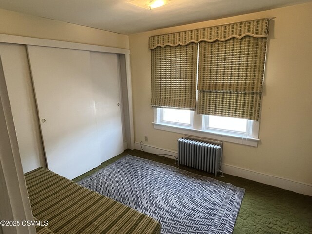 1409 Scott St, Kulpmont, PA 17834 - unfurnished bedroom featuring radiator heating unit, dark colored carpet, and a closet