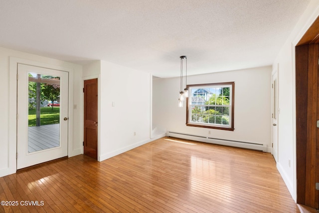 110 W 8th St, Watsontown, PA 17777 - empty room featuring a baseboard heating unit, light wood-type flooring, and a textured ceiling