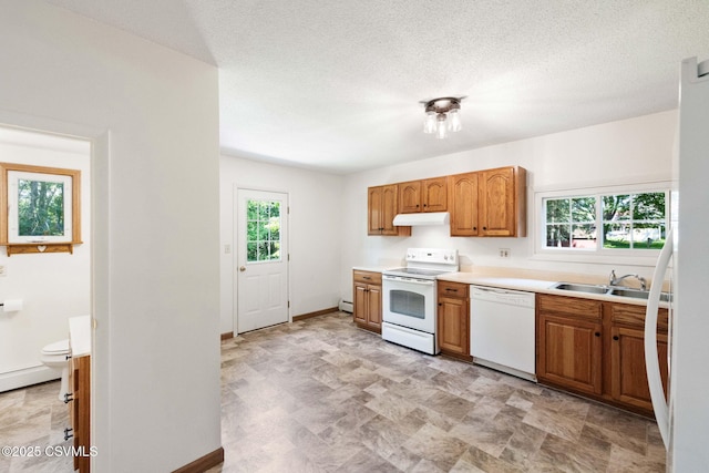 110 W 8th St, Watsontown, PA 17777 - kitchen with white appliances, under cabinet range hood, light countertops, and brown cabinets